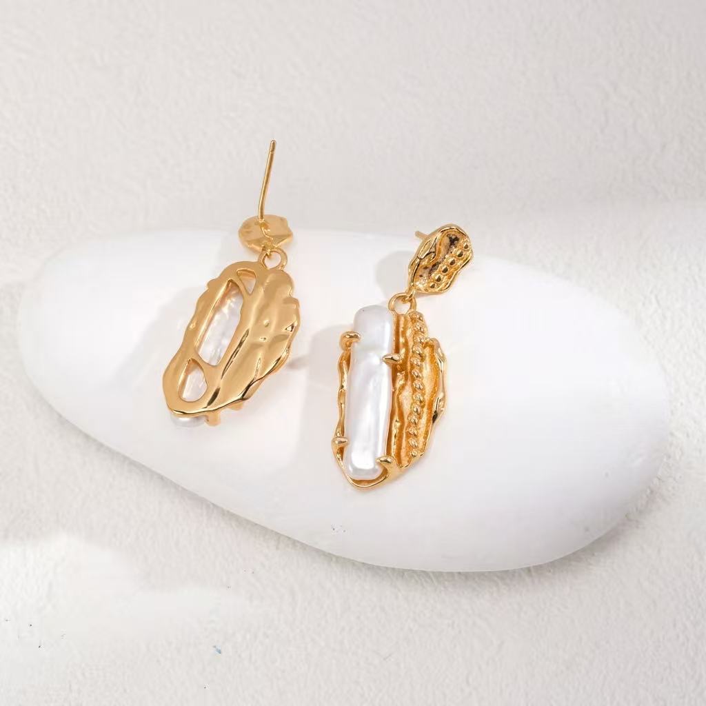 Close-up of auric pearl statement earrings with sculptural vintage gold texture